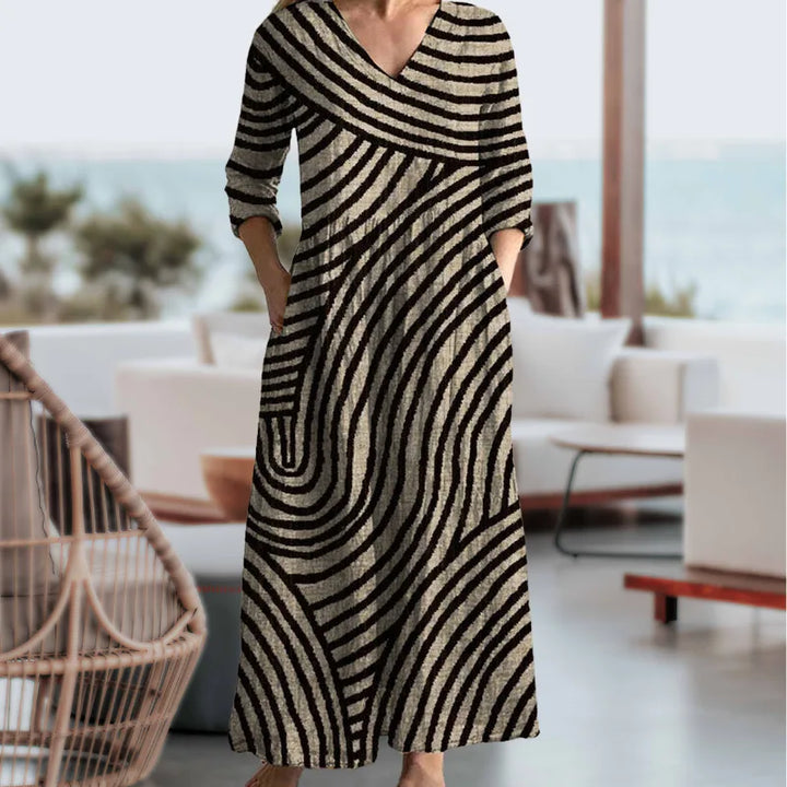 Brown wavy striped maxi dress on standing model, side view