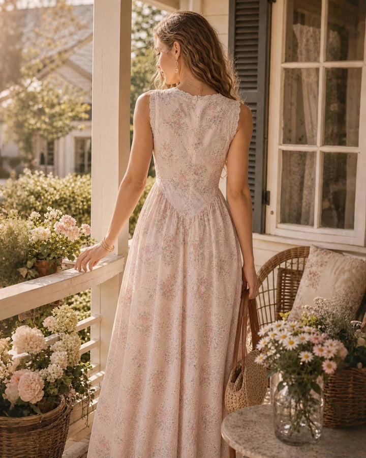 Side view of a model in a flowing pink maxi dress with lace trim