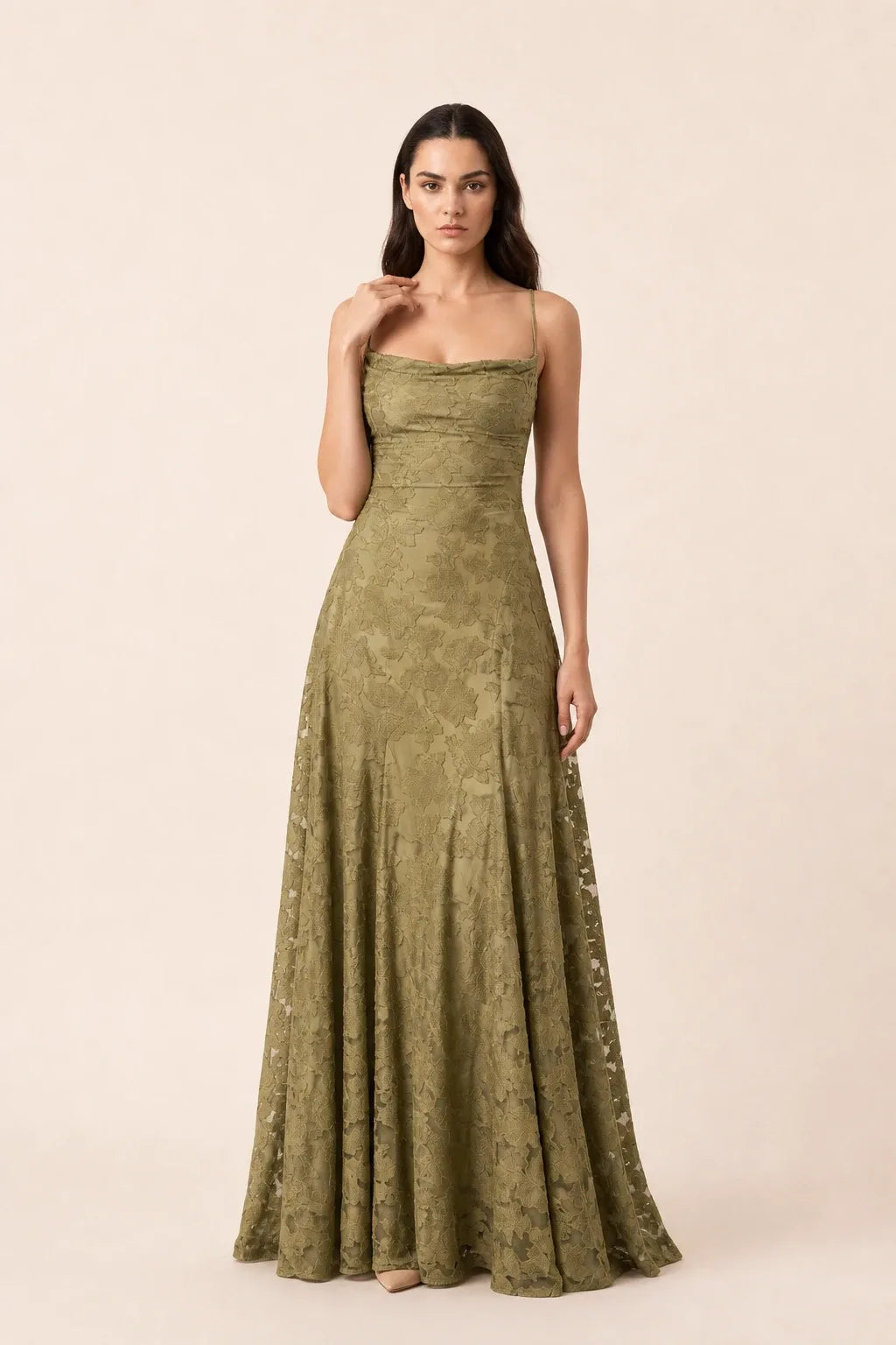 Olive green lace appliqué gown on model in contrapposto stance