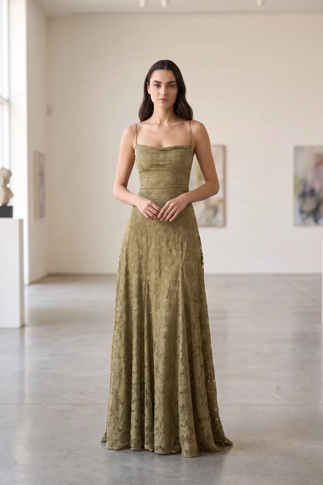 Model wearing olive green lace appliqué gown in lifestyle setting