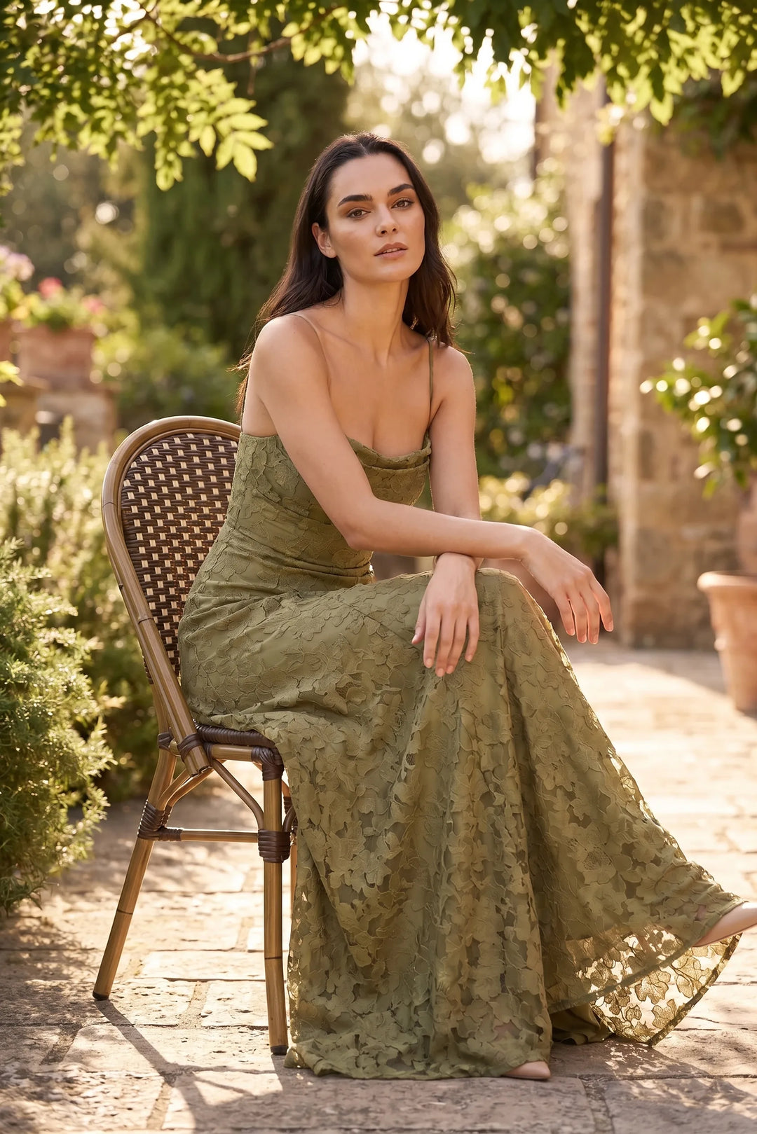 Model wearing olive green lace appliqué gown in outdoor lifestyle setting