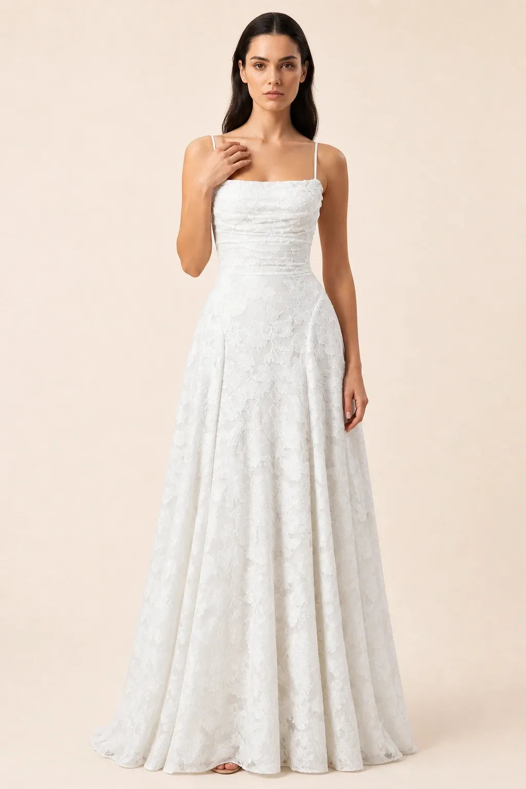 White lace appliqué gown on model in contrapposto stance
