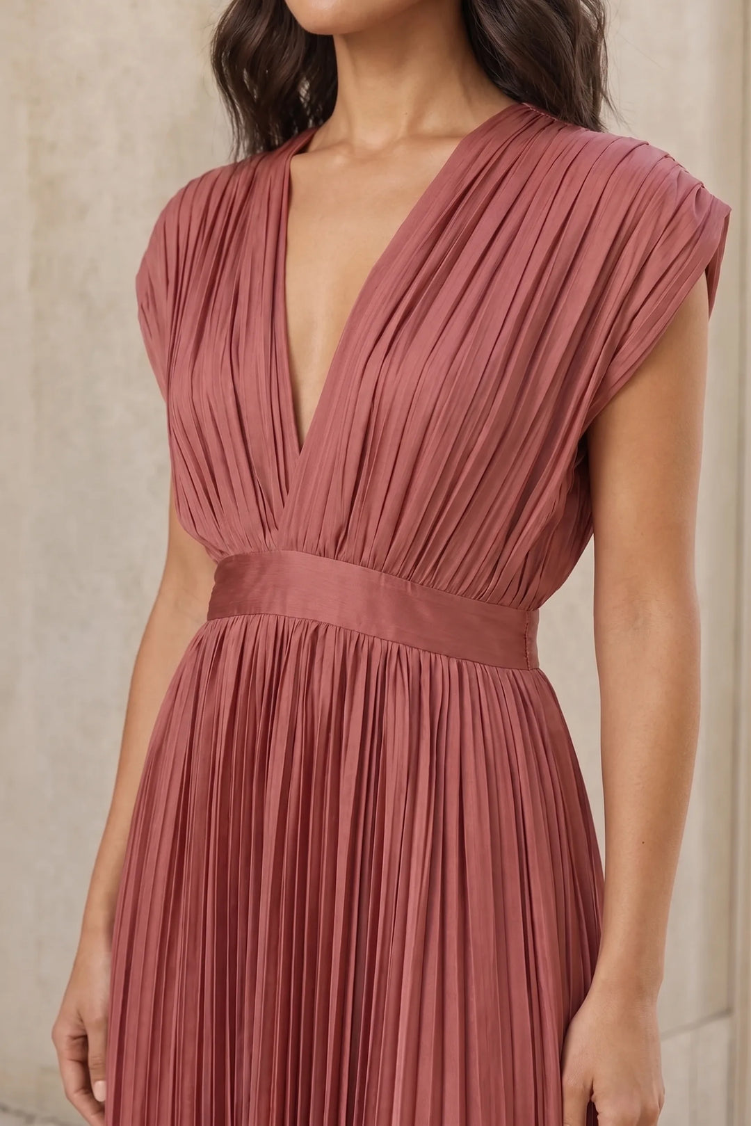 Close-up detail of antique pink pleated midi dress fabric and construction