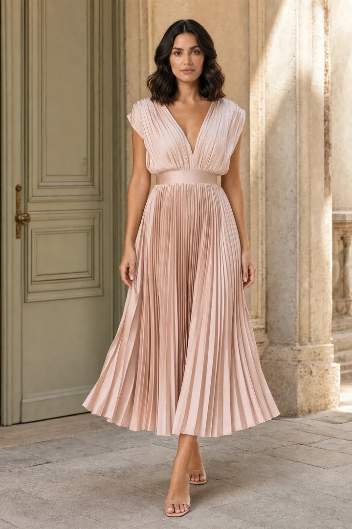 Champagne pleated midi dress on a model in a contrapposto stance