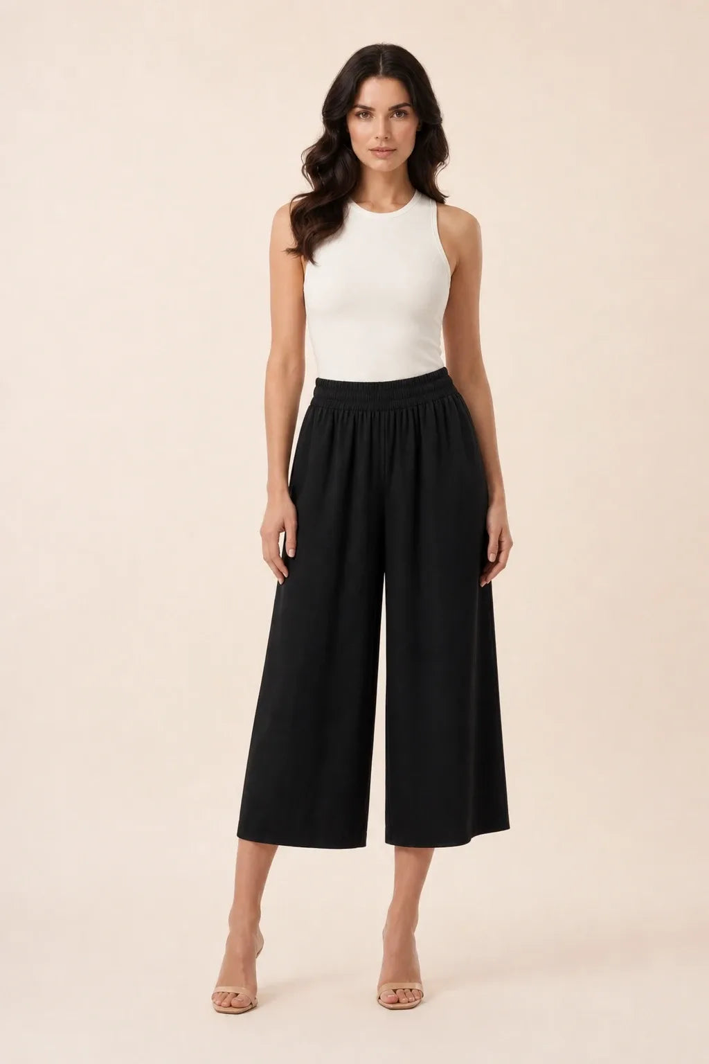 Black smocked culotte on model in contrapposto stance, elasticated waistband and wide cropped legs