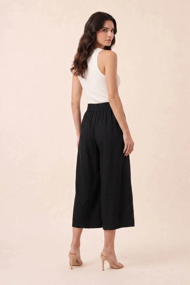 Black smocked culotte on model in three-quarter turn, showing back and side silhouette