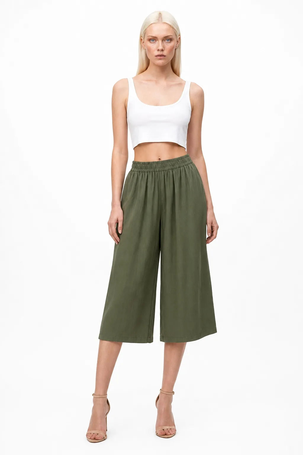Green smocked culotte pants on a model in a contrapposto stance
