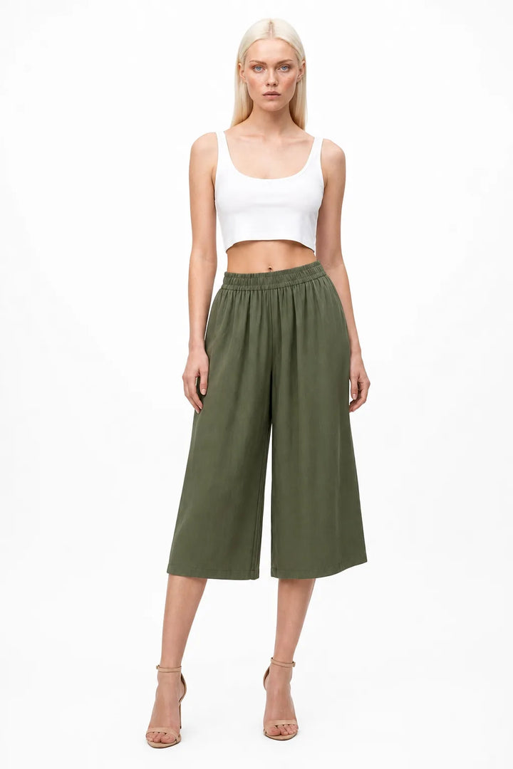 Green smocked culotte pants on a model in a contrapposto stance