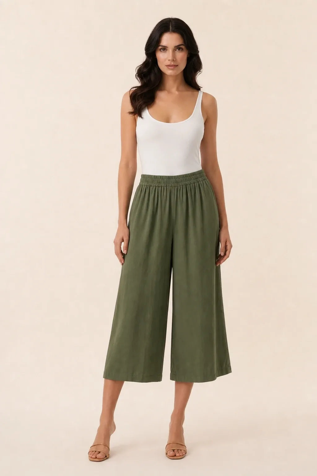 Green smocked culotte on model in contrapposto stance, elasticated waistband and wide cropped legs