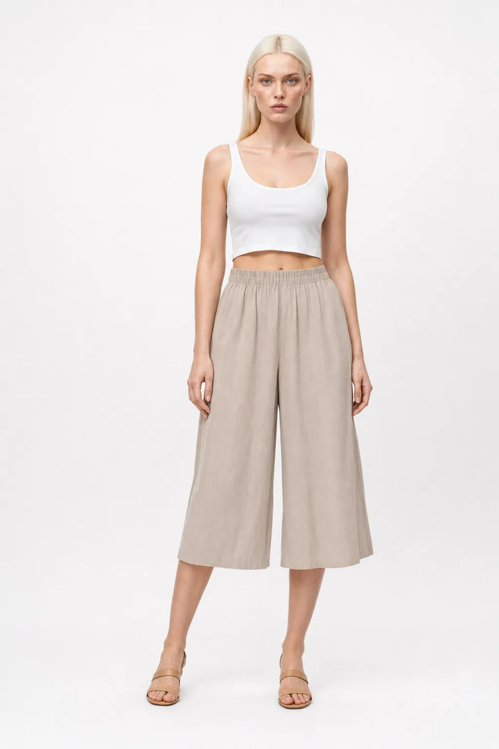 Khaki smocked culotte pants on a model in a contrapposto stance