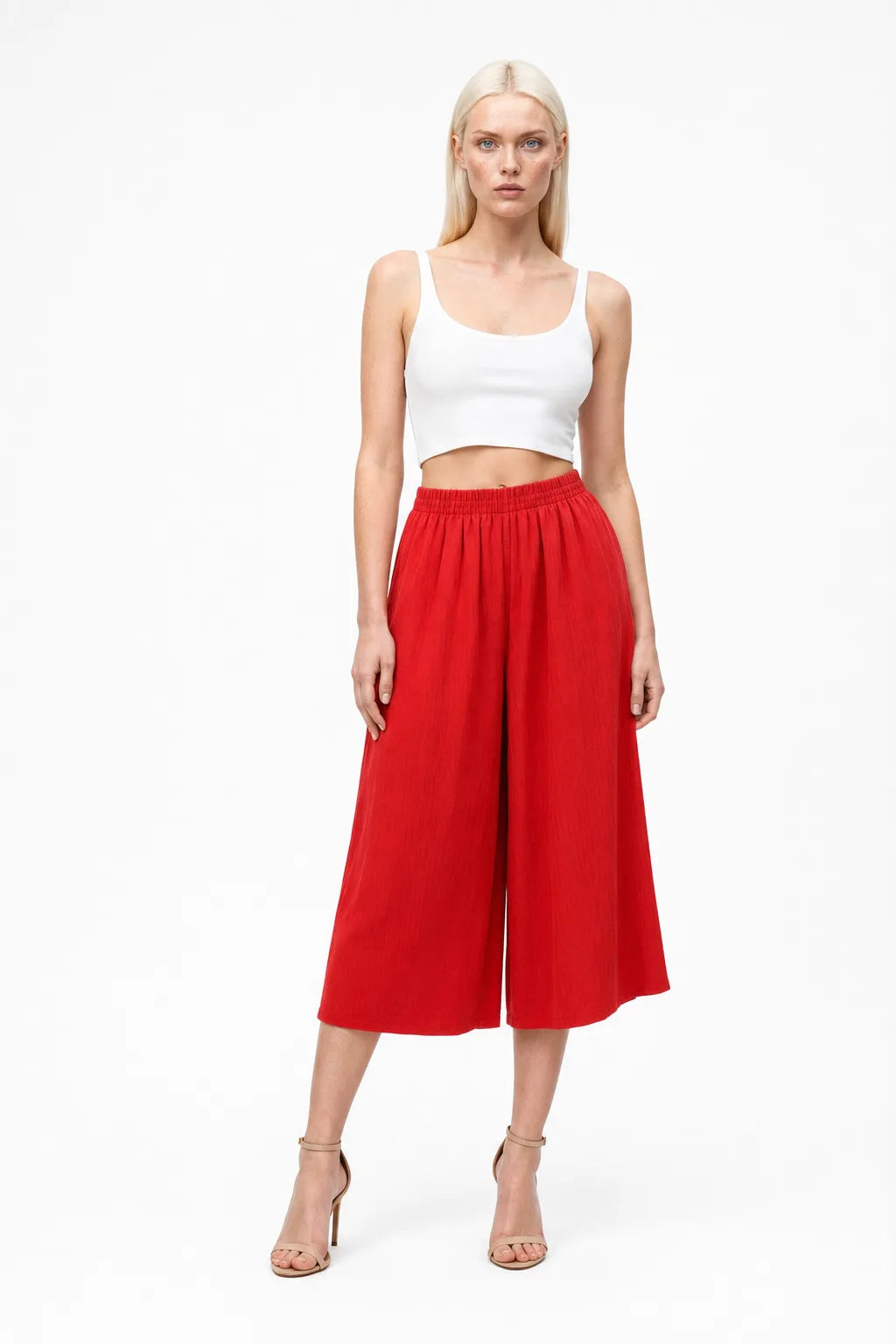 Red smocked culotte pants on a model in a contrapposto stance
