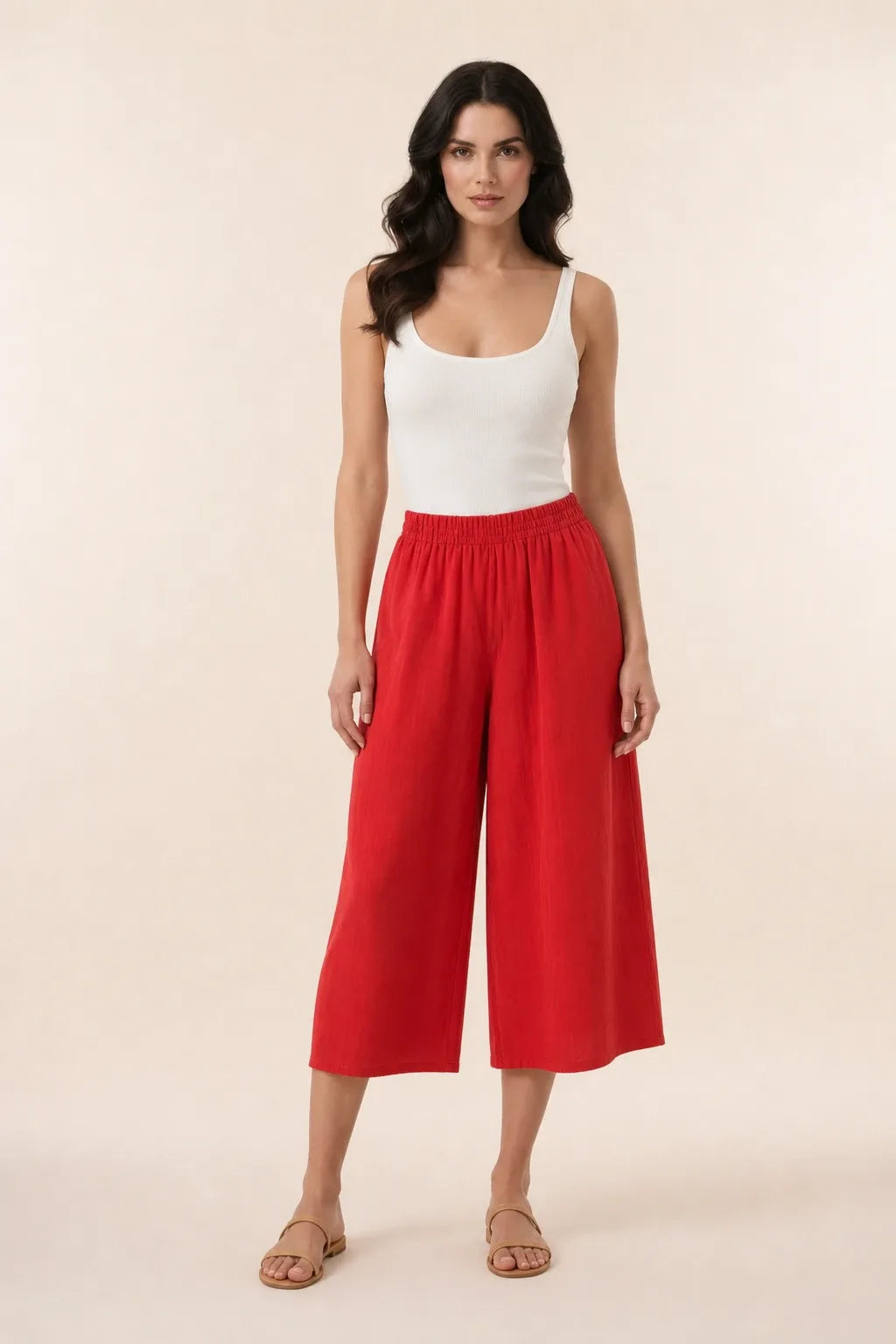 Red smocked culotte on model in contrapposto stance, elasticated waistband and wide cropped legs