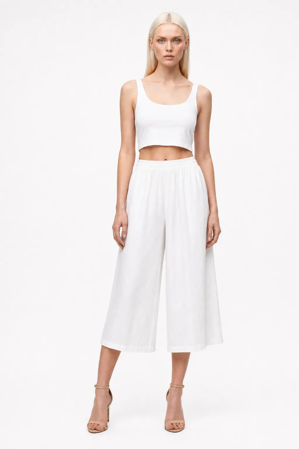White smocked culotte pants on a model in a contrapposto stance