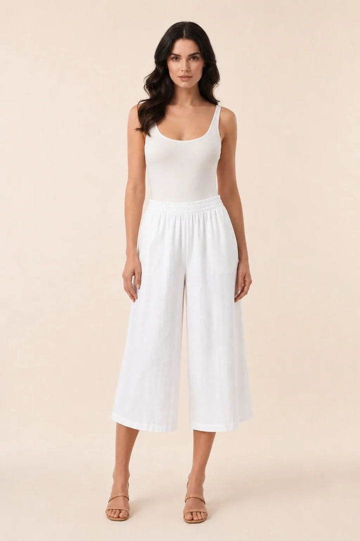 White smocked culotte on model in contrapposto stance, elasticated waistband and wide cropped legs