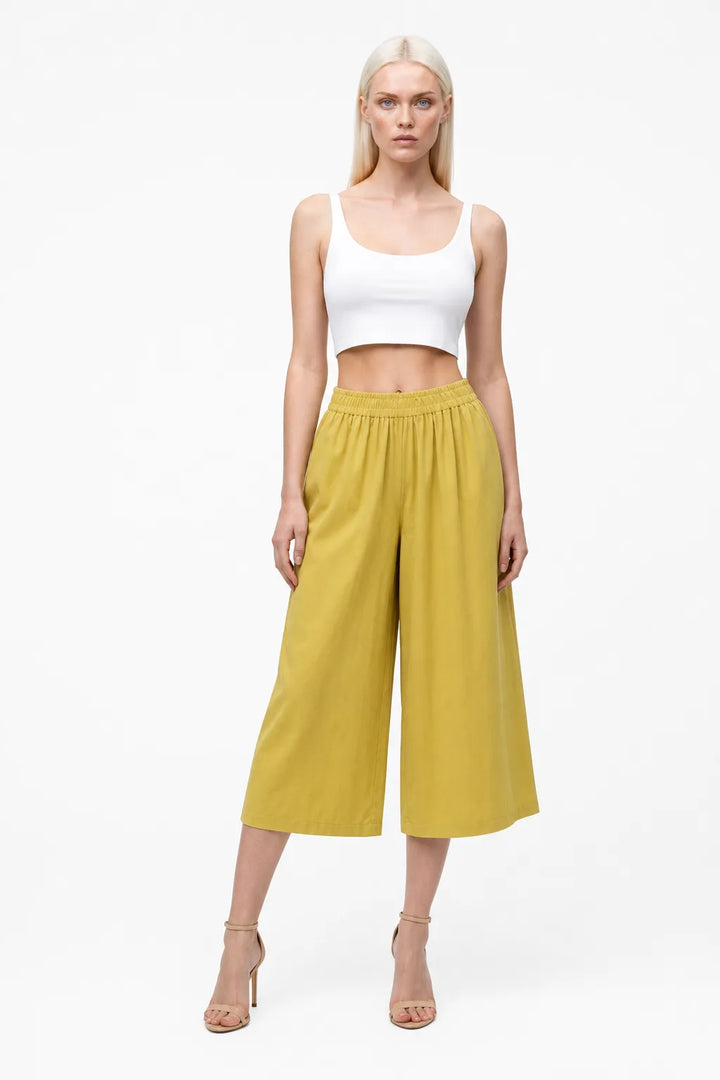 Yellow smocked culotte pants on a model in a contrapposto stance