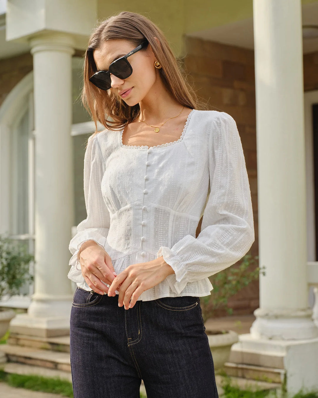 Side view of a woman in a white broderie corset blouse highlighting the fitted silhouette