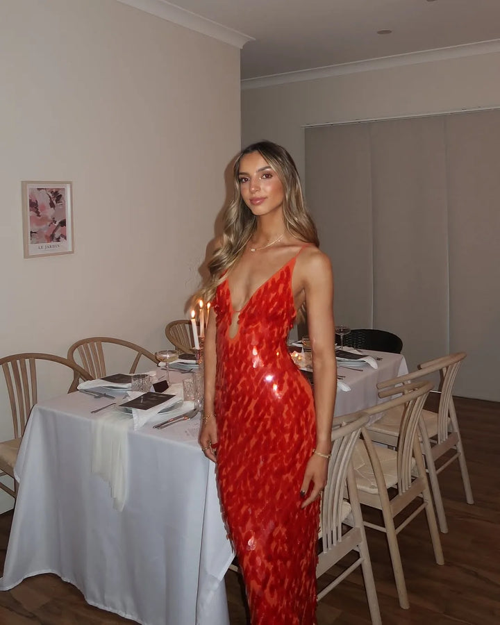 Close-up detail of red sequin fabric on a floor-length gown