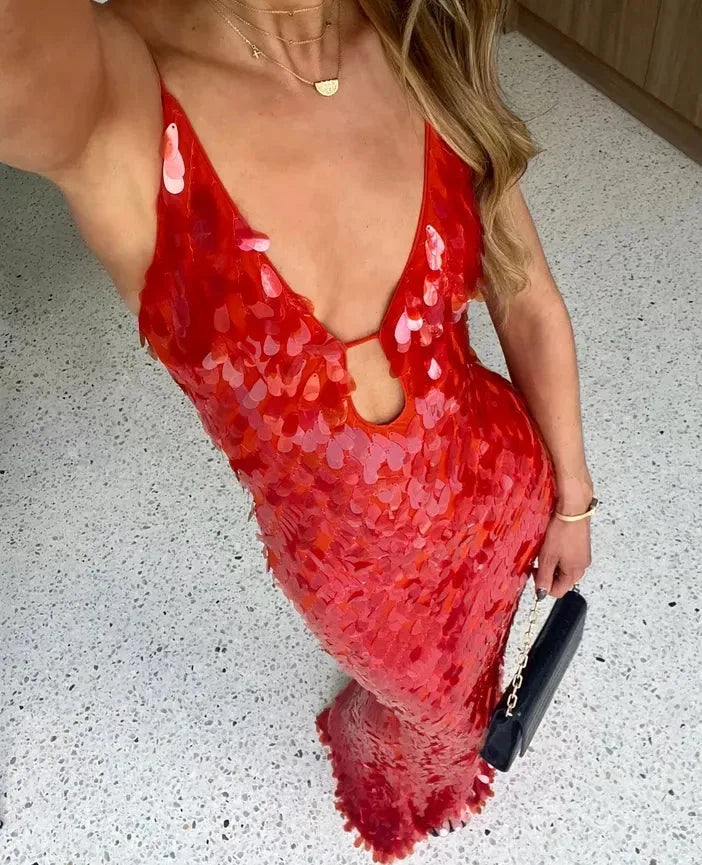 Woman in a red sequin backless gown in a side profile, full-length view