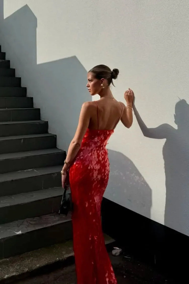 Woman in a red sequin backless gown at a three-quarter turn, full-length view