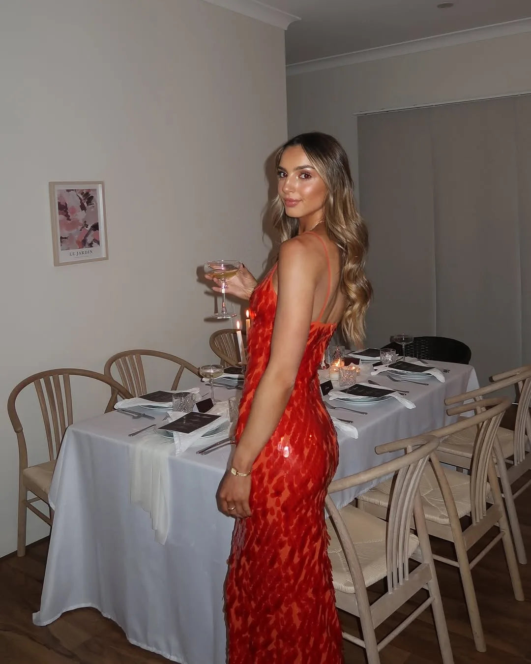 Woman in a red sequin backless gown, alternate full-length view
