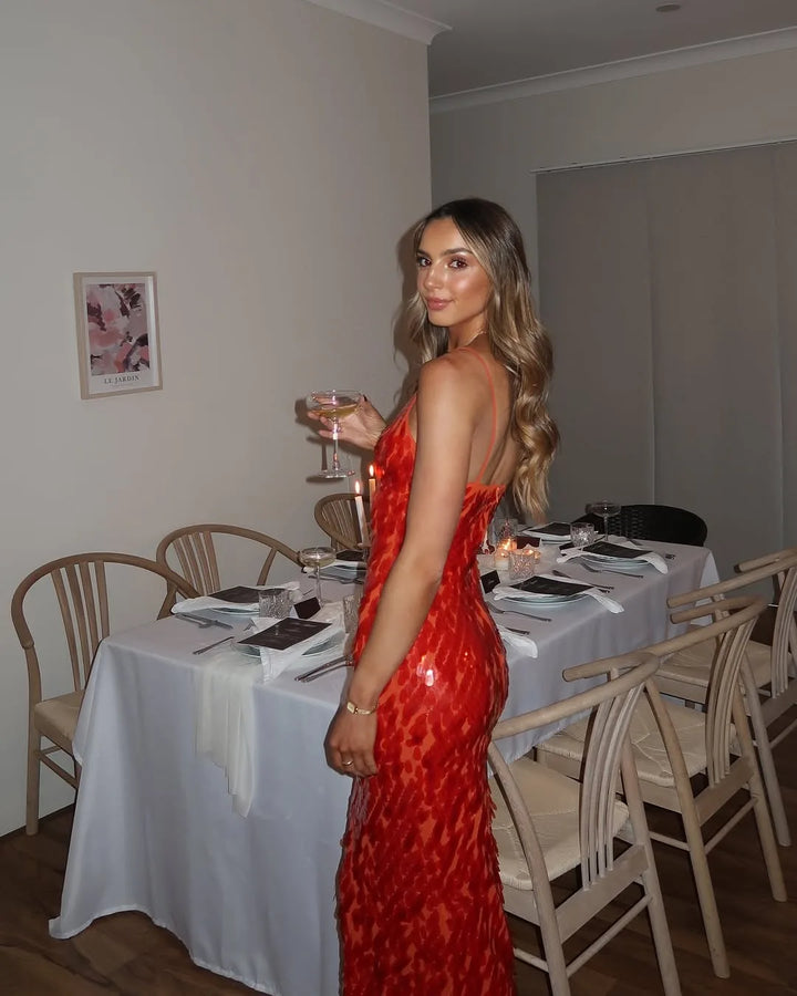 Woman in a red sequin backless gown, alternate full-length view
