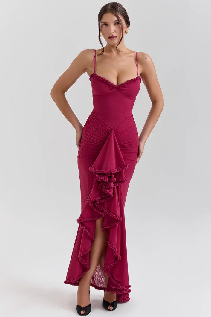 Model in side pose wearing a burgundy ruffle slit maxi dress with tiered hem