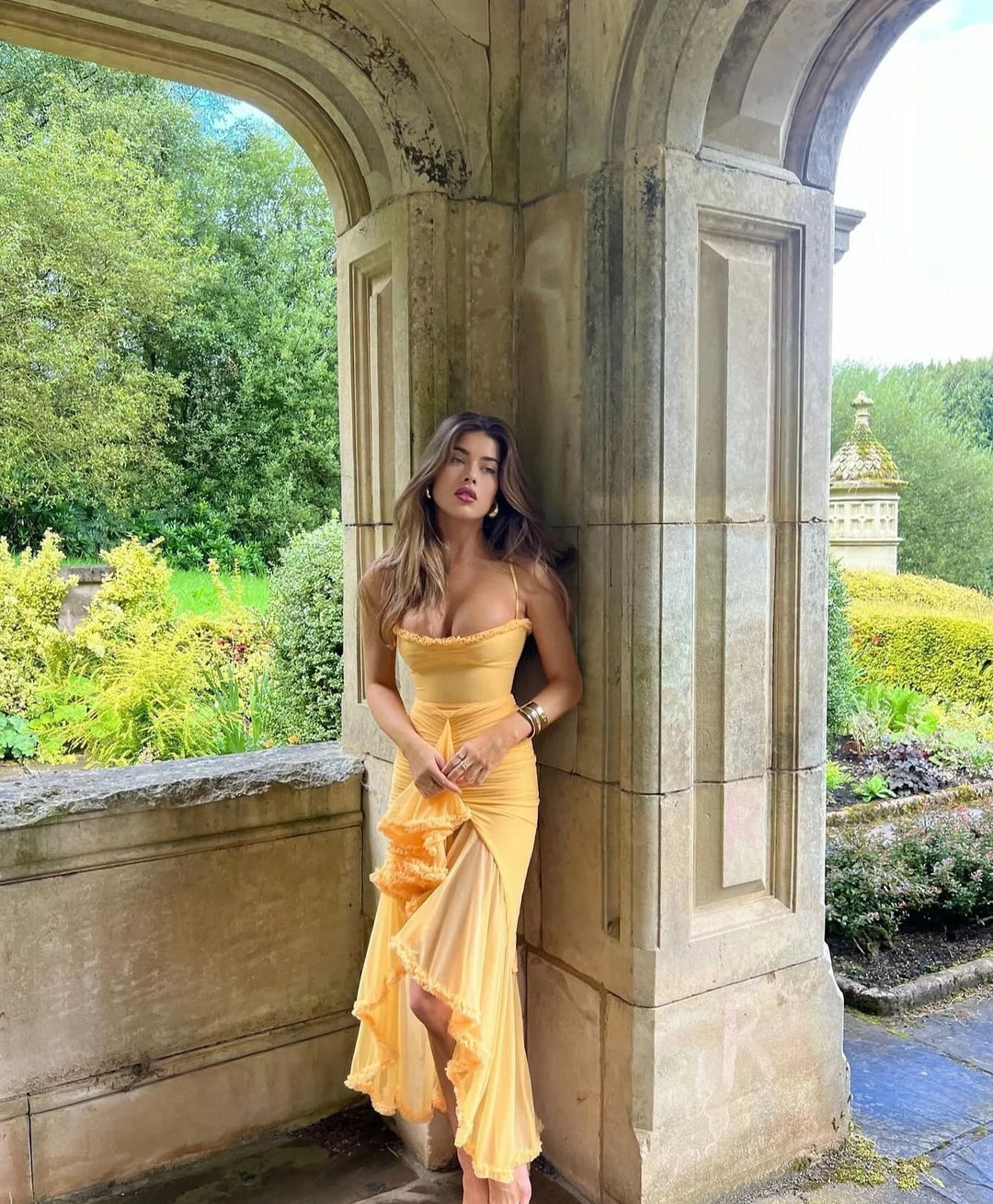 Model in yellow ruffle slit maxi dress showing side slit detail