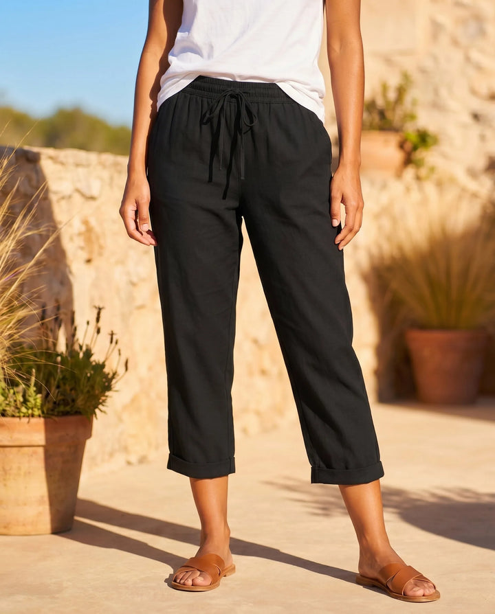 Black drawstring capri pants on model, relaxed fit with tied waistband detail