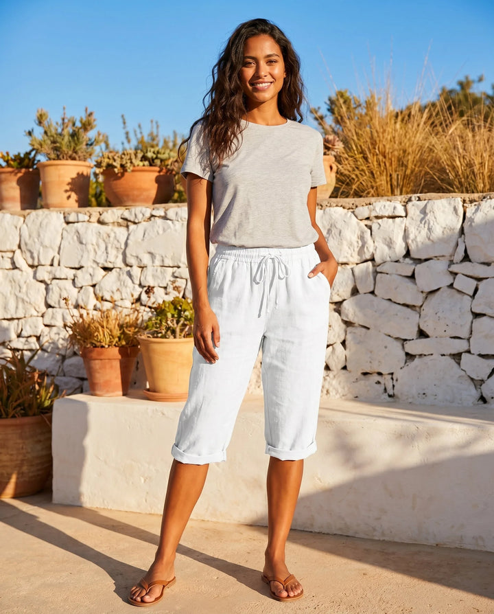 White drawstring capri pants on model from the side, highlighting cropped length and fit