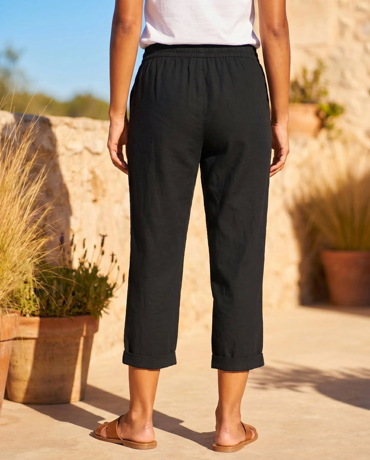 White drawstring capri pants on model, full-length view with soft gathered waist