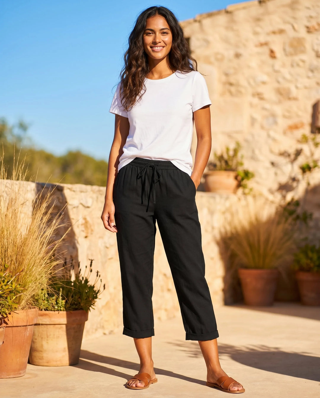 White drawstring capri pants on model, styled view highlighting cropped ankle-length hem