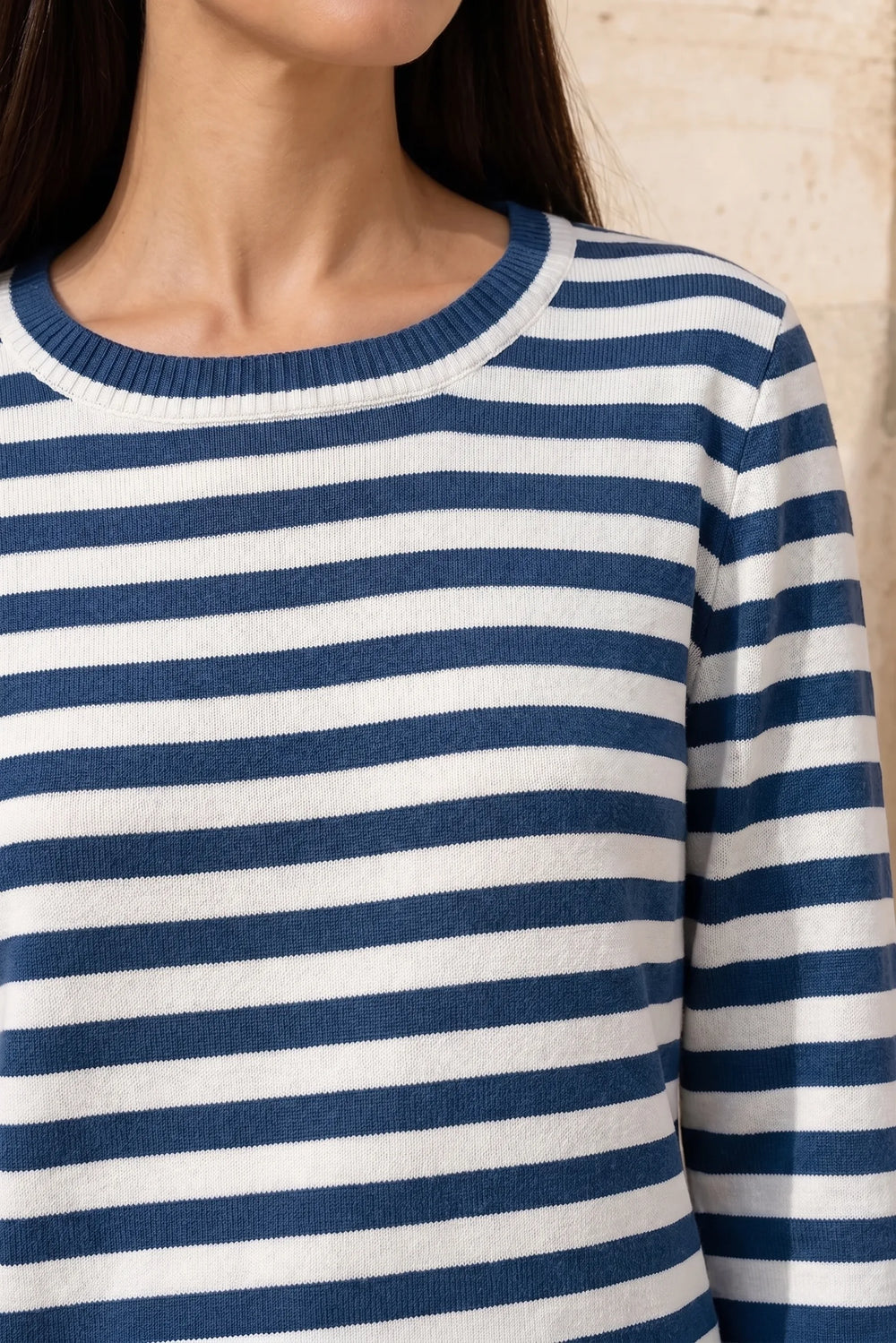 Close-up detail of blue striped long sleeve top fabric and construction