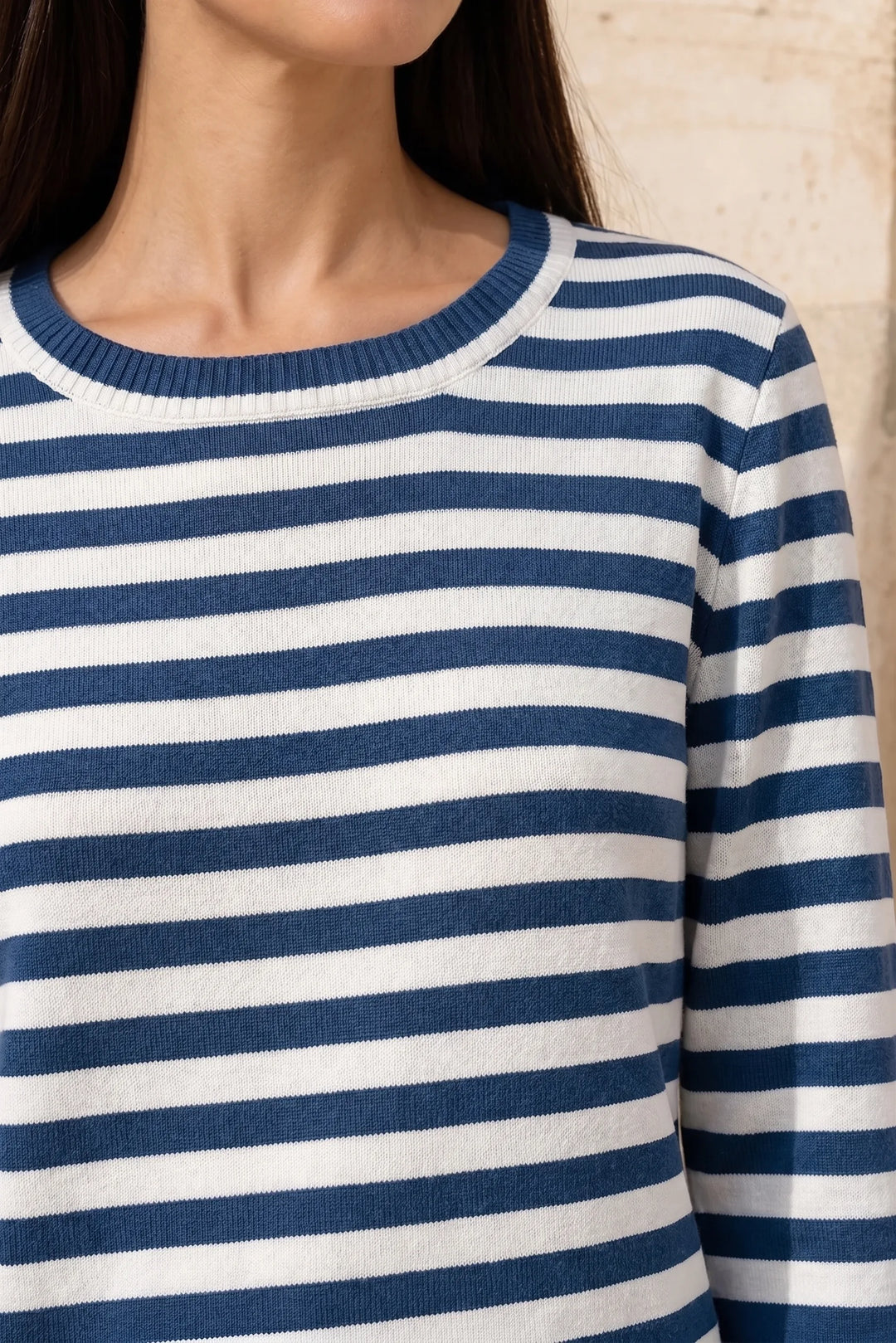 Close-up detail of blue striped long sleeve top fabric and construction