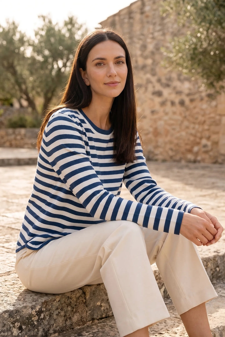 Model wearing blue striped long sleeve top in outdoor lifestyle setting