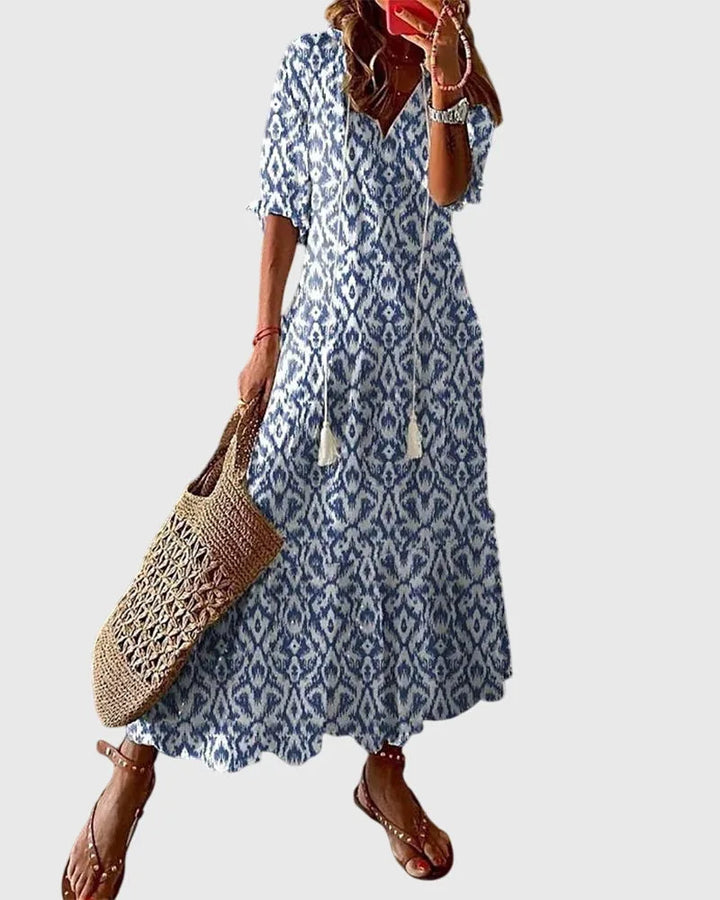Blue ikat print midi dress on model facing forward, featuring a relaxed silhouette and short sleeves