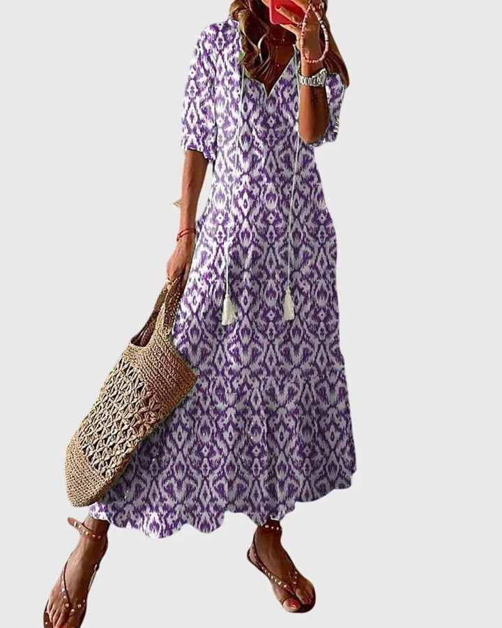 Purple ikat print midi dress on model in side profile, highlighting the silhouette and hem length