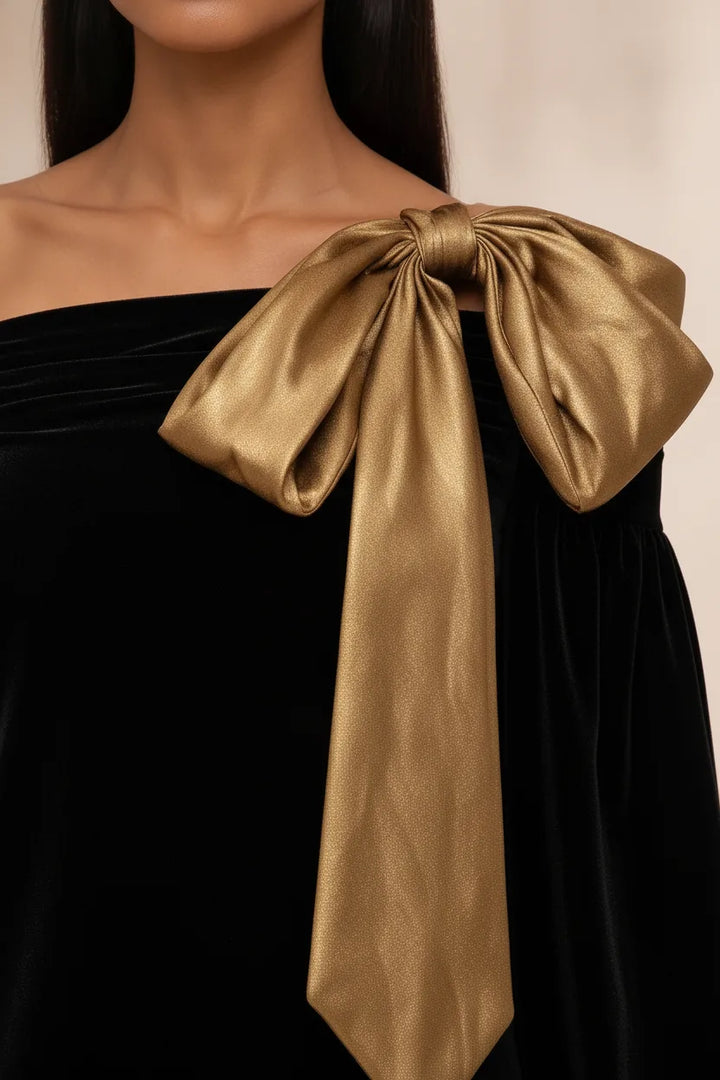 Close-up detail of a black velvet mini dress bow embellishment