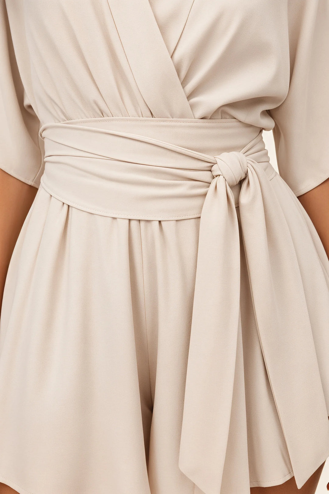 Close-up detail of beige kimono wrap playsuit fabric and tie