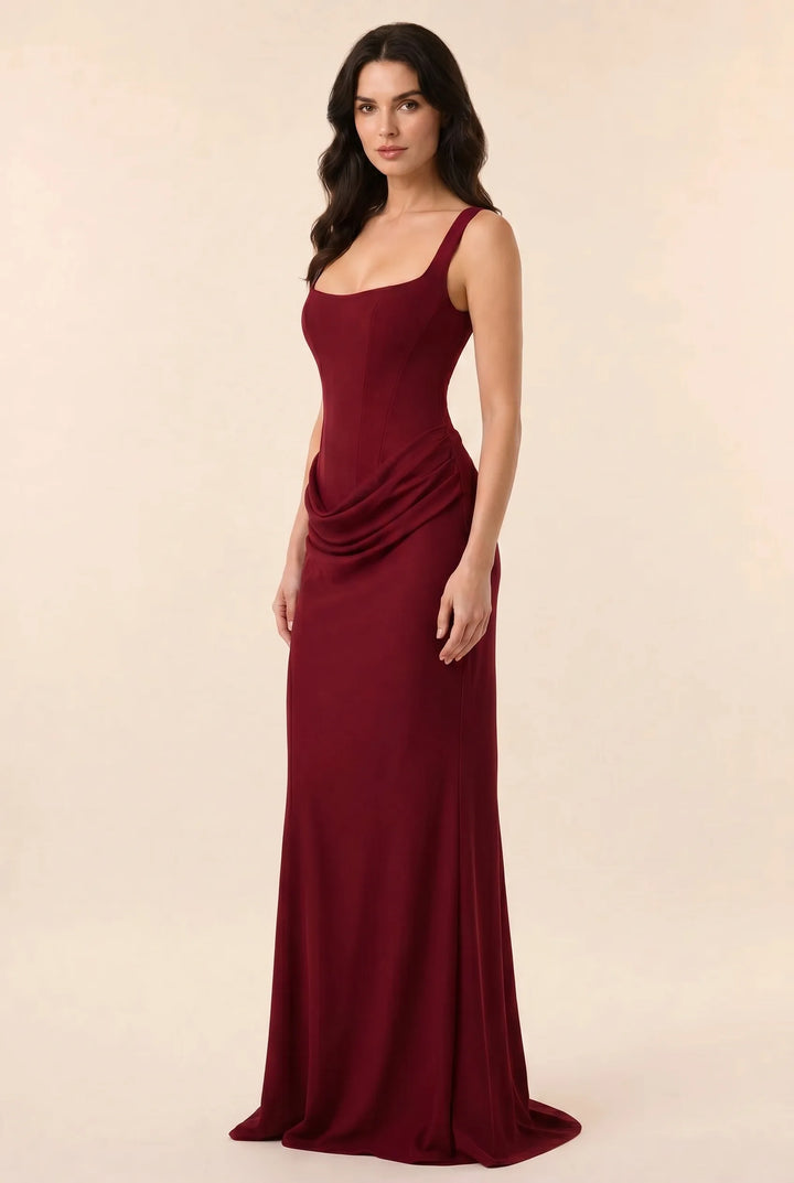 Burgundy corset draped gown on a model in a three-quarter turn