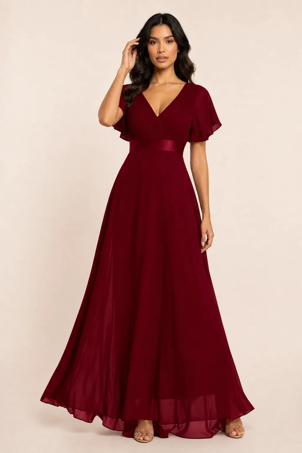 Burgundy flutter sleeve maxi dress on model in contrapposto stance