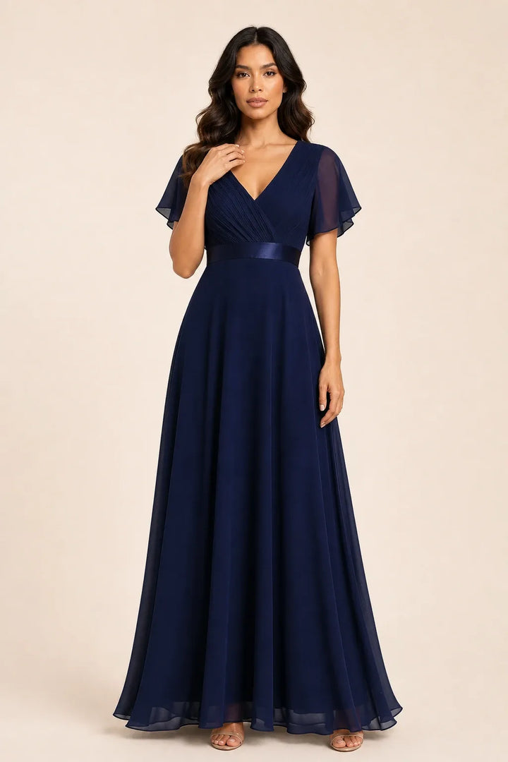 Navy blue flutter sleeve maxi dress on model in contrapposto stance