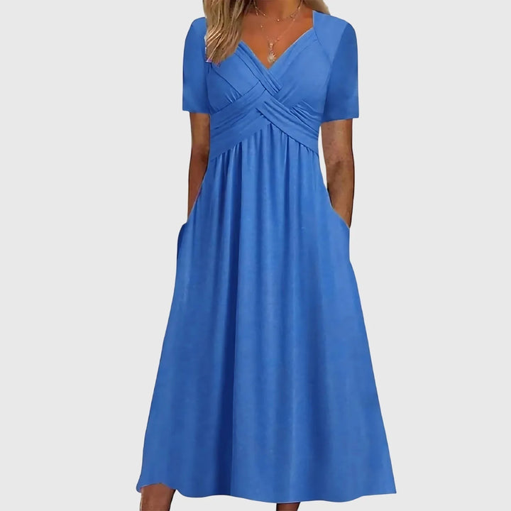 Blue cross-wrap midi dress on model in three-quarter turn