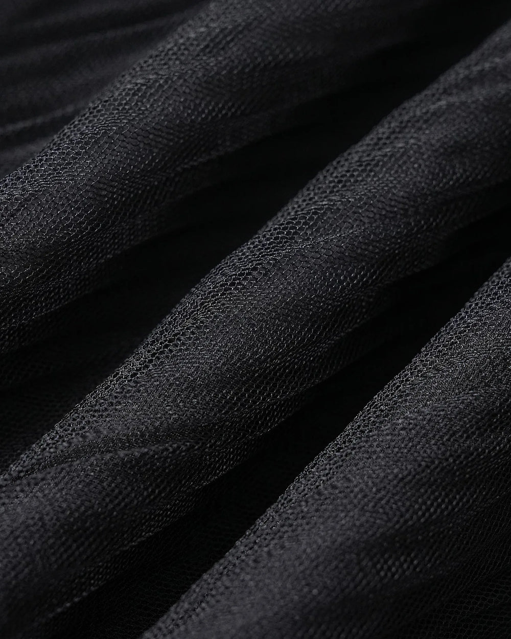 Close-up of rose appliqué detail on black midi dress fabric