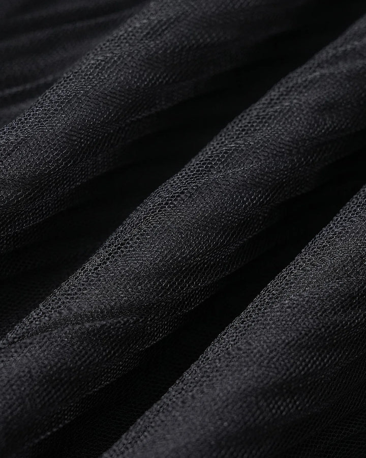 Close-up of rose appliqué detail on black midi dress fabric