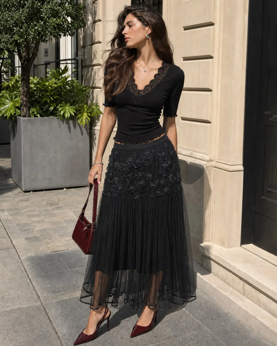Black midi dress with rose appliqués, model facing forward
