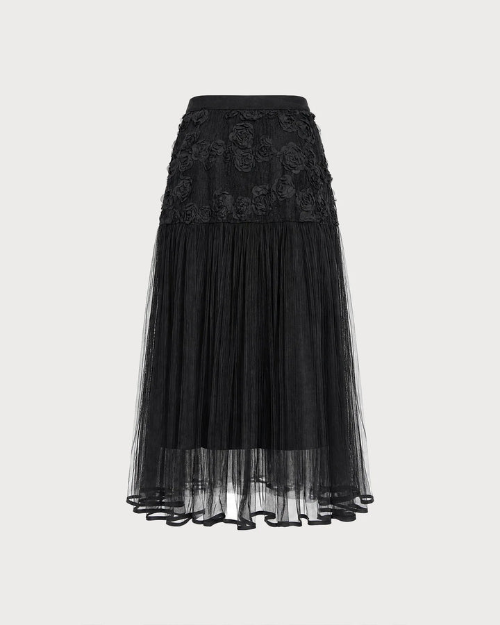 Black midi dress with floral appliqués, model in side profile