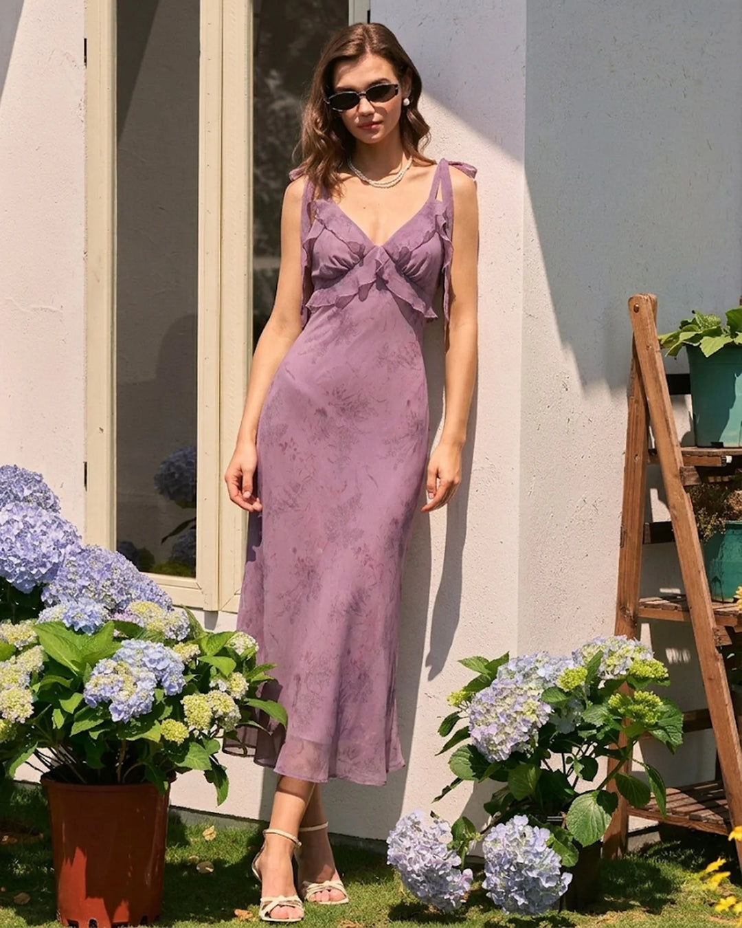 Model in a three-quarter turn wearing a purple ruffle tie strap midi dress