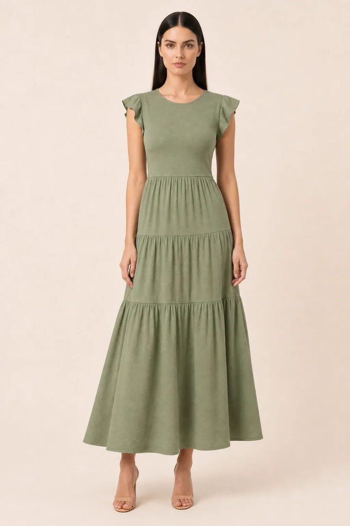 Dark green smocked tiered midi dress on model in contrapposto stance