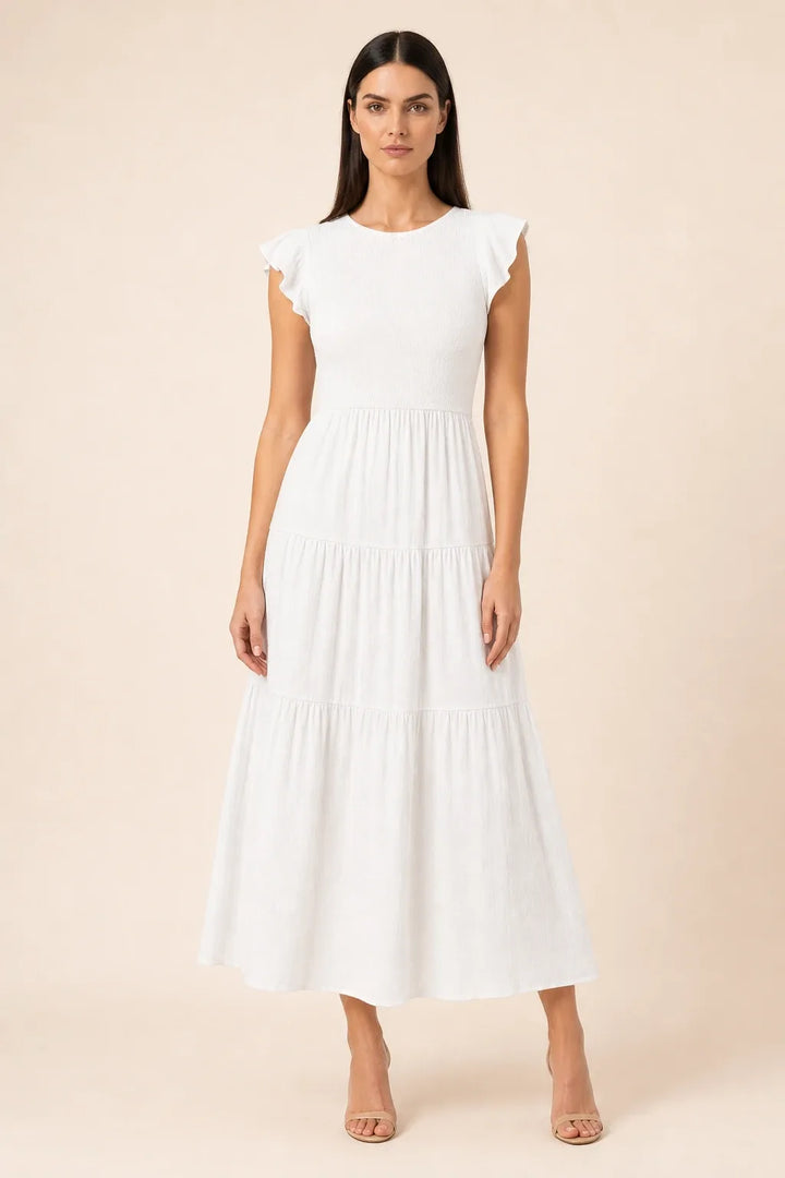 White smocked tiered midi dress on model in contrapposto stance