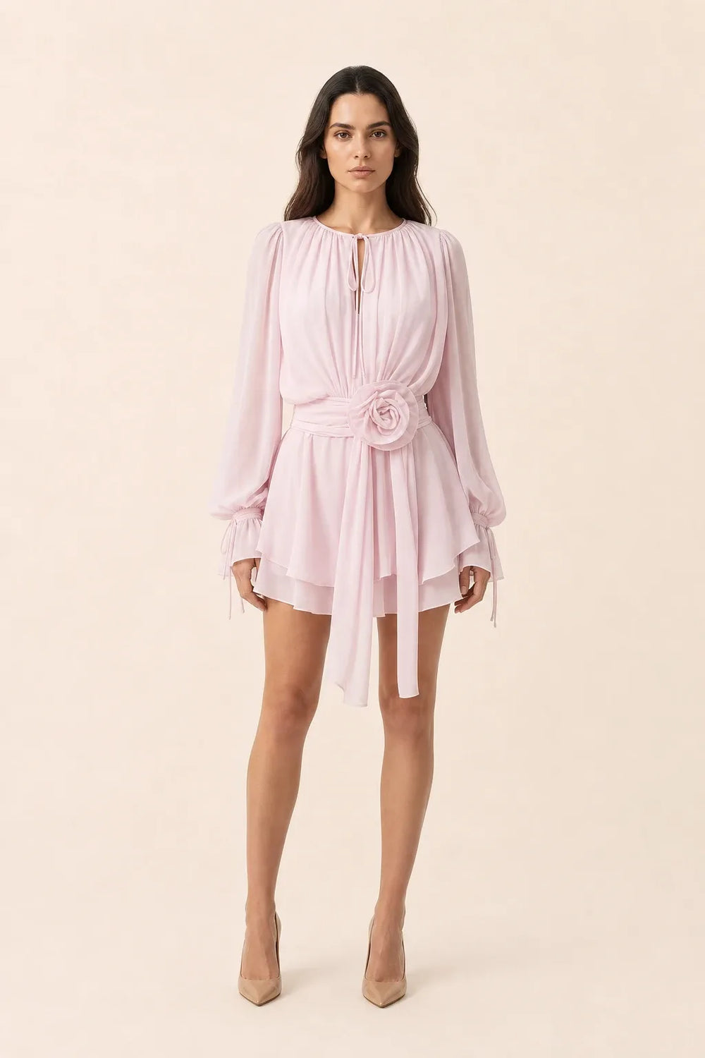 White mini dress with rosette sash detail on model in contrapposto stance